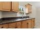 Kitchen featuring granite countertops, wood cabinets, and stainless steel sink at 332 Sand Pine Trl, Winter Haven, FL 33880