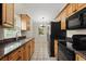 Bright kitchen features granite countertops, stainless steel refrigerator, and black appliances at 332 Sand Pine Trl, Winter Haven, FL 33880