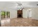 Open living area with brick fireplace, tile flooring, and access to a screened patio at 332 Sand Pine Trl, Winter Haven, FL 33880