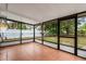 Enclosed patio with tile flooring, black aluminum frame windows, and an exterior view of the yard at 332 Sand Pine Trl, Winter Haven, FL 33880