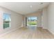 Open living room features neutral colors, vaulted ceilings and backyard views from windows and sliding doors at 4015 Gardenia Ave, Lake Hamilton, FL 33851