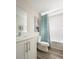 Bright bathroom with white vanity, blue shower curtain, and neutral wall decor at 4027 Gardenia Ave, Lake Hamilton, FL 33851