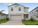 Charming two-story home showcasing a well-maintained lawn, attached garage, and a cheerful light blue front door at 4027 Gardenia Ave, Lake Hamilton, FL 33851