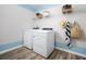 Well-lit laundry room with modern washer and dryer, shelving, and stylish accents at 4027 Gardenia Ave, Lake Hamilton, FL 33851