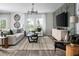 Inviting living room with contemporary decor, large windows, stylish furniture, and a decorative accent wall at 4027 Gardenia Ave, Lake Hamilton, FL 33851