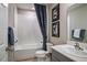 Bright bathroom with a shower and tub combination, framed art and a gray vanity sink with a large mirror at 4039 Gardenia Ave, Lake Hamilton, FL 33851