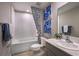 Bright bathroom with a shower and tub combination, framed art and a gray vanity sink with a large mirror at 4039 Gardenia Ave, Lake Hamilton, FL 33851