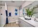 Well-lit bathroom featuring double sinks, stylish blue accents, a tiled shower and tub combination, and modern fixtures at 4039 Gardenia Ave, Lake Hamilton, FL 33851