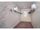 Walk-in closet with ample shelving, clothes hangers, carpeted floors, and a window for natural light at 4039 Gardenia Ave, Lake Hamilton, FL 33851
