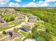 Scenic aerial shot of a vibrant residential area surrounded by lush trees and a serene pond at 421 Sierra Mike Blvd, Lake Alfred, FL 33850