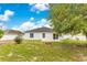 Spacious backyard with lush green grass, mature trees, and a cozy patio at 421 Sierra Mike Blvd, Lake Alfred, FL 33850