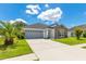 Attractive one-story house featuring a spacious driveway, two-car garage, and lush green lawn at 421 Sierra Mike Blvd, Lake Alfred, FL 33850