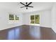 Bright living room features wood floors, large windows, and sliding door to backyard at 421 Sierra Mike Blvd, Lake Alfred, FL 33850