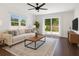 Cozy living room with stylish furniture, wood floors, and sliding glass doors to backyard at 421 Sierra Mike Blvd, Lake Alfred, FL 33850