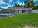 Large, grassy backyard with an above-ground pool and patio area at 4730 Se 141St Pl, Summerfield, FL 34491