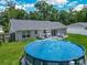 Aerial view of backyard with above-ground pool, patio and large grassy space at 4730 Se 141St Pl, Summerfield, FL 34491