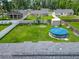 Aerial view of fenced backyard featuring above ground pool, shed, fire pit and green grass at 4730 Se 141St Pl, Summerfield, FL 34491
