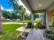Inviting covered front porch with tile flooring, seating, and lovely landscaping details at 4730 Se 141St Pl, Summerfield, FL 34491