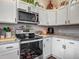 Well-organized kitchen with white cabinets, modern appliances, and granite countertops at 4730 Se 141St Pl, Summerfield, FL 34491