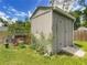 Exterior shot of backyard storage shed with ramp, garden, and chicken coop on a grassy lot at 4730 Se 141St Pl, Summerfield, FL 34491