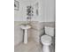 Bathroom featuring tiled walls, a pedestal sink, and a modern toilet at 536 Ave G Se, Winter Haven, FL 33880