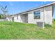 Side of home highlighting the covered patio, healthy green grass, and freshly painted exterior at 800 Reggie Rd, Winter Haven, FL 33884