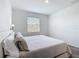 Sunlit bedroom features carpet, neutral bedding, side table, and a large window at 800 Reggie Rd, Winter Haven, FL 33884