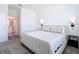 Well-lit bedroom with carpet, sconce lighting, neutral bedding, and doorway to bathroom at 800 Reggie Rd, Winter Haven, FL 33884