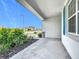 Comfortable front porch with blue shutters, concrete floor, and lush landscaping at 800 Reggie Rd, Winter Haven, FL 33884