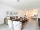 Bright, open-concept living room with modern decor, including a large sofa and tile flooring throughout at 800 Reggie Rd, Winter Haven, FL 33884