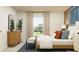 Bedroom with a large window, neutral decor, wood dresser, and a comfortable bed with stylish pillows and linens at 1269 Deepwater Cir, Eagle Lake, FL 33839