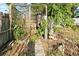 Fenced backyard with a chicken coop, garden ornaments, and lush green foliage at 1852 E Fern Rd, Lakeland, FL 33801