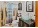 Bathroom featuring a clear glass bowl sink, decorative shower curtain, and a wooden framed mirror at 1852 E Fern Rd, Lakeland, FL 33801