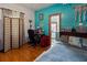 Stylish bedroom with hardwood floors, turquoise walls, and eclectic decor, creating a unique space at 1852 E Fern Rd, Lakeland, FL 33801
