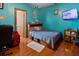Bright bedroom featuring a bed with storage and vibrant turquoise walls, creating a cozy and unique living space at 1852 E Fern Rd, Lakeland, FL 33801