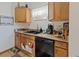 Traditional kitchen featuring light wood cabinets, a black dishwasher, and a double basin sink at 1852 E Fern Rd, Lakeland, FL 33801