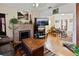 Open-concept living room with hardwood floors, a brick fireplace, and access to the dining area at 1852 E Fern Rd, Lakeland, FL 33801