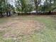 Spacious backyard, partially grassed, with shade trees and a wood fence in the distance at 2212 Ne 11 Ct, Ocala, FL 34470