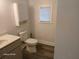 Bright bathroom with a sink, toilet, medicine cabinet, and a window for natural light at 2212 Ne 11 Ct, Ocala, FL 34470