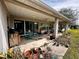 Covered patio with sliding glass doors, ceiling fan, concrete flooring, and outdoor plants at 11928 Se 91St Cir, Summerfield, FL 34491