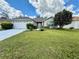 Charming single-story home with a well-manicured lawn, mature trees, and a two-car garage at 11928 Se 91St Cir, Summerfield, FL 34491