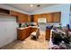Outdated kitchen featuring wood cabinets, laminate countertops, and an empty refrigerator space at 11928 Se 91St Cir, Summerfield, FL 34491
