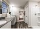 Bright bathroom featuring double vanity, wood-look floors, and a view into the bedroom at 1629 Sage Ave, Haines City, FL 33844