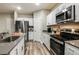 Modern kitchen featuring stainless steel appliances, white cabinets, and sleek countertops at 1629 Sage Ave, Haines City, FL 33844