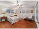Bedroom featuring hardwood floors, ceiling fan, sitting area, and natural light from two windows at 208 Se 32Nd Ave, Ocala, FL 34471