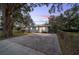 Charming single-story home with a large driveway, mature trees, and twilight sky at 208 Se 32Nd Ave, Ocala, FL 34471