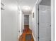 Hallway with neutral walls, hardwood floors, and white doors leading to various rooms at 208 Se 32Nd Ave, Ocala, FL 34471