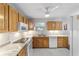 Kitchen with white appliances, wood cabinets, and marble countertops at 208 Se 32Nd Ave, Ocala, FL 34471