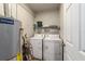 Laundry room features a pair of washing machines and utility shelving at 208 Se 32Nd Ave, Ocala, FL 34471