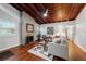 Open living room with brick fireplace, hardwood floors, wood-clad vaulted ceilings and plenty of natural light at 208 Se 32Nd Ave, Ocala, FL 34471